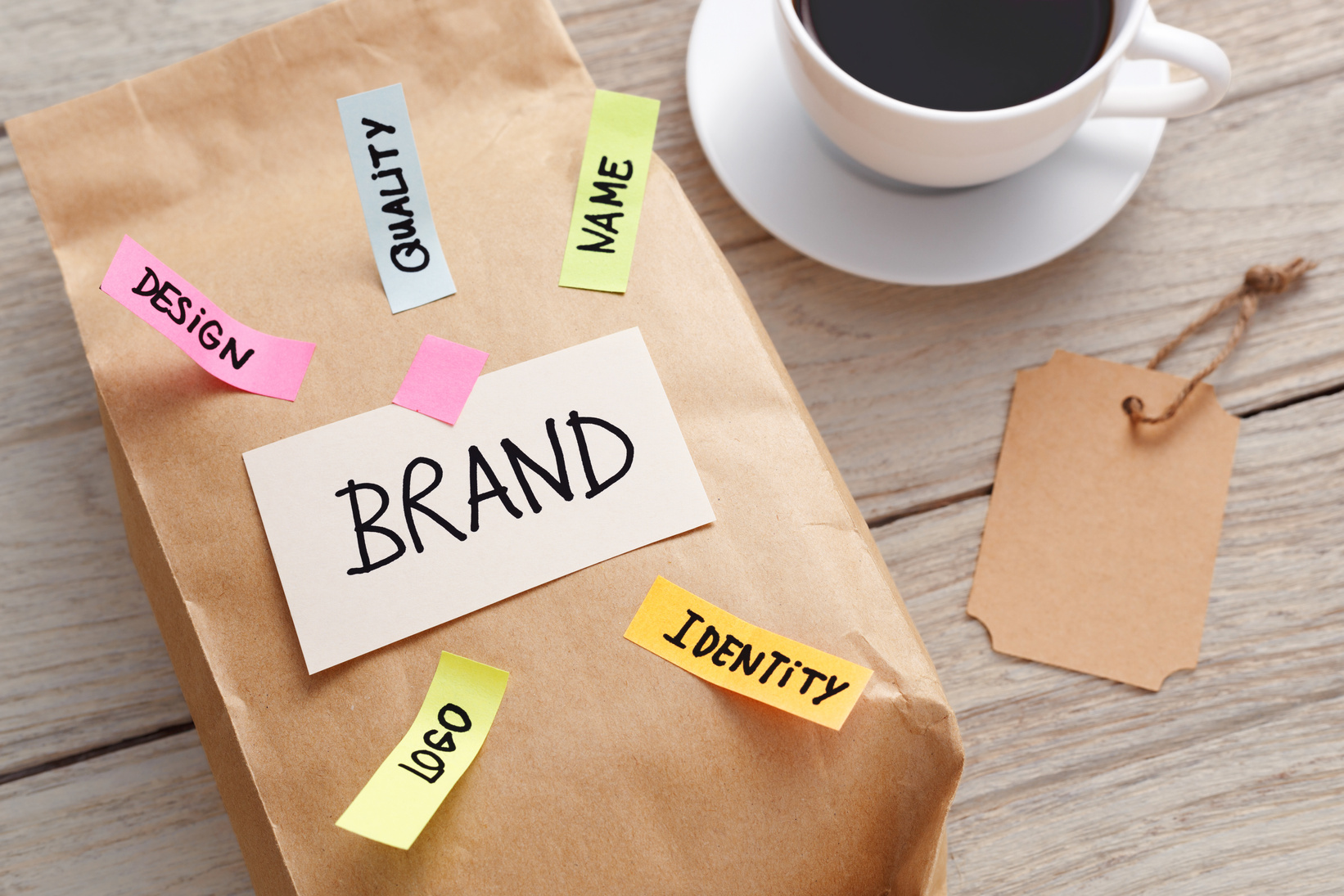 a brown paper bag with sticky notes and a cup of coffee on a wooden table